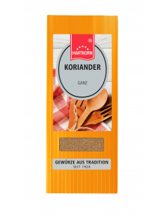 Flachbeutel mit der Aufschrift „KORIANDER Ganz“, im Hintergrund Holzlöffel und kariertes Tuch.