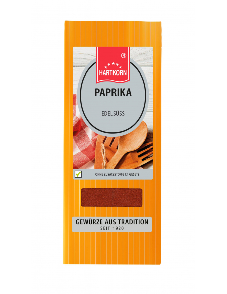Flachbeutel mit der Aufschrift „PAPRIKA Edelsüß“, daneben hölzerne Kochlöffel auf kariertem Tuch. Flachbeutel mit der Aufschrift „PAPRIKA Edelsüß“, daneben hölzerne Kochlöffel auf kariertem Tuch.