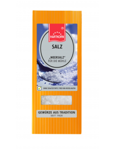 Flachbeutel mit der Aufschrift „SALZ Meersalz für die Mühle“ vor Löffel mit grobem Salz