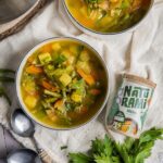 Klare Gemüsesuppe mit grünen Bohnen, Karotten und Kartoffeln in einer weißen Schale, daneben das Naturami Gewürzsalz Original