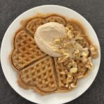 Eine Waffel, getippt mit Gewürzjoghurt und kleinen Walnüssen