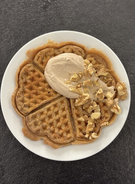 Eine Waffel, getippt mit Gewürzjoghurt und kleinen Walnüssen