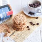 Schwedische Haferkekse auf einem Papier. Im Hintergrund Hartkorn Oatmeal Gewürz und eine Tasse mit Kaffeebohnen.