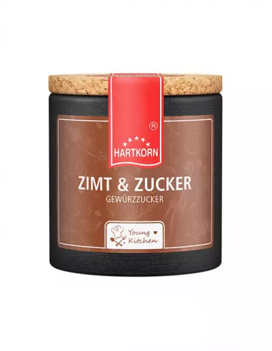 Pappdose mit Korkdeckel und beigefarbenem Etikett, beschriftet mit „Zimt & Zucker“.