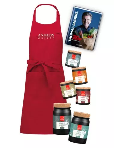 Rote Kochschürze mit „Thomas Anders“-Schriftzug, ein Kochbuch von Thomas Anders, vier Gewürzdosen und zwei Keramiktöpfchen.